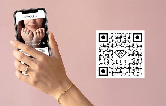 Ženská ruka držící telefon se zobrazenou obrazovkou Apart Diamond Clubu a QR kódem