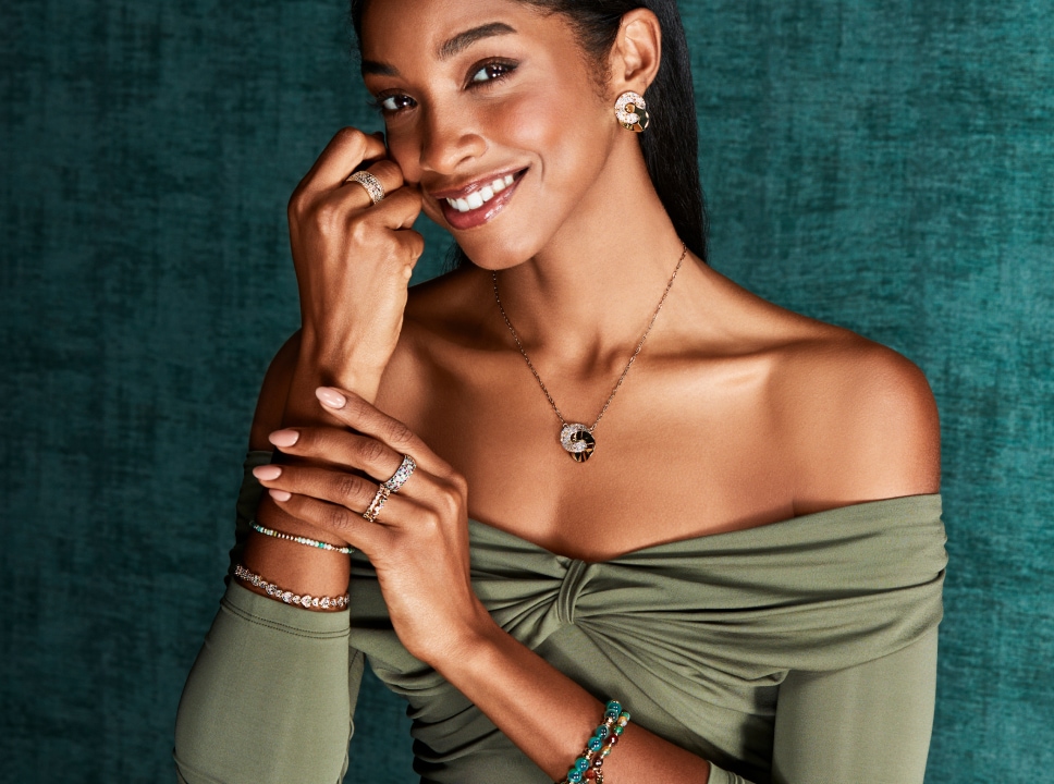 Yaritza Reyes-Zmyslowska v zelených šatech předvádí stříbrné šperky s korálky Artelioni