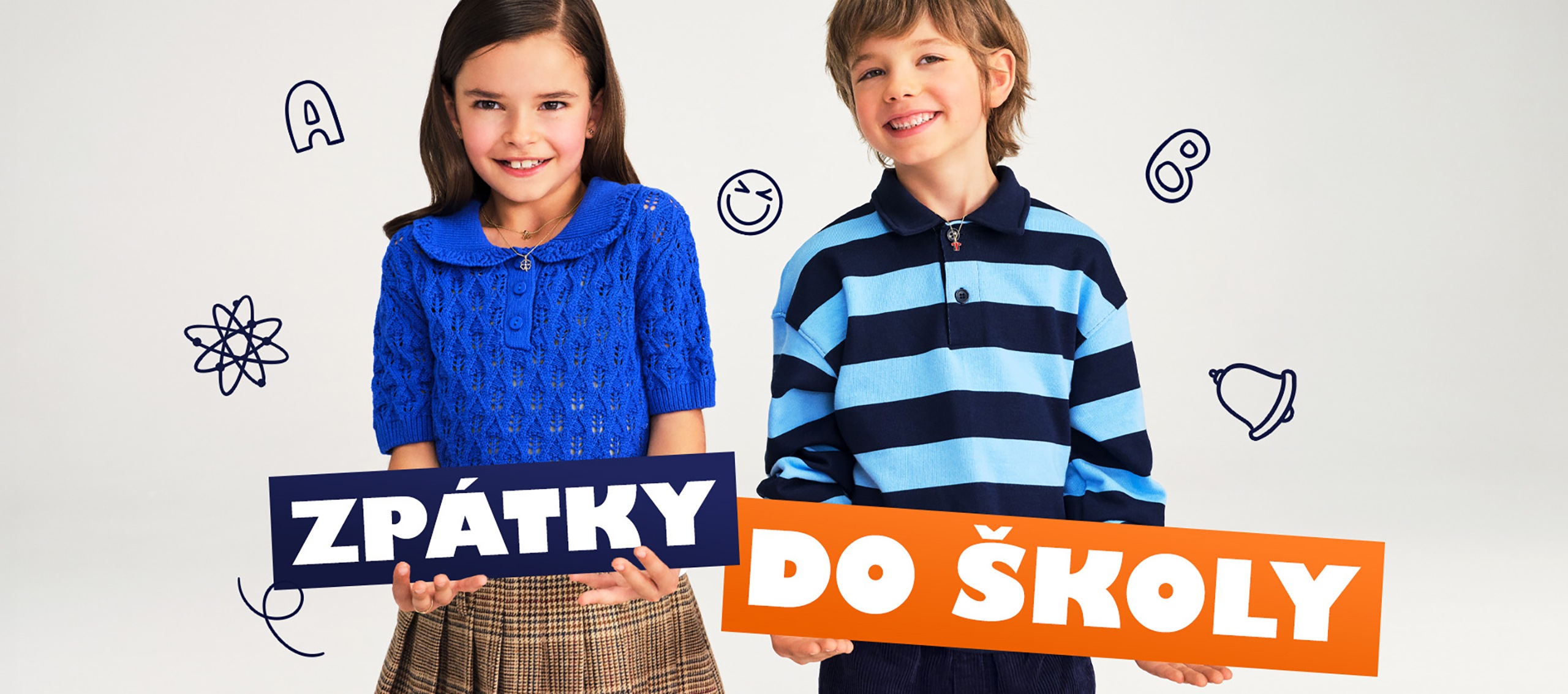 Dívka a chlapec drží ceduli s pozdravem do školy