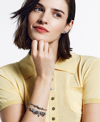 A woman shows off silver jewellery from the Beads collection with an infinity motif.