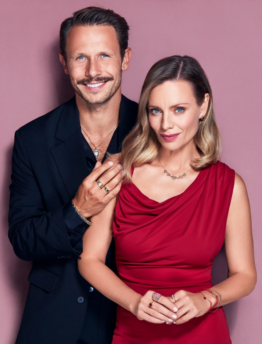 Magdalena Boczarska v červených šatech s Mateuszem Banasiukem představují zlaté šperky - prsteny, náušnice, náramky, pečetní prsteny