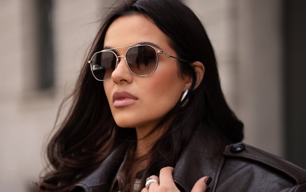 A model in a leather jacket showing off sunglasses.