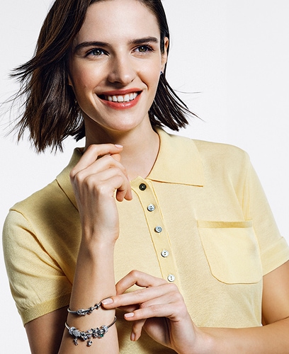 A model shows off silver bracelets with pendants from the Beads collection with a floral motif