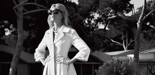 Black and white photo of Anja Rubik presenting pearls