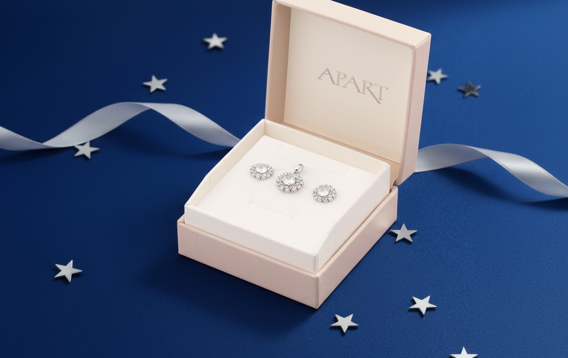 A box with the Apart logo, containing earrings and a cubic zirconia chain.