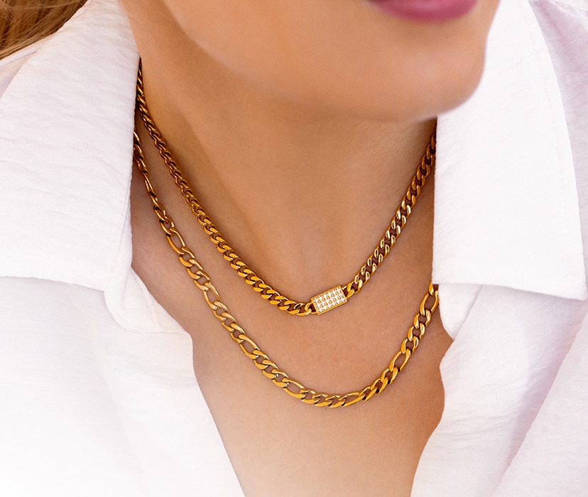 a woman in a white shirt shows off gold chains