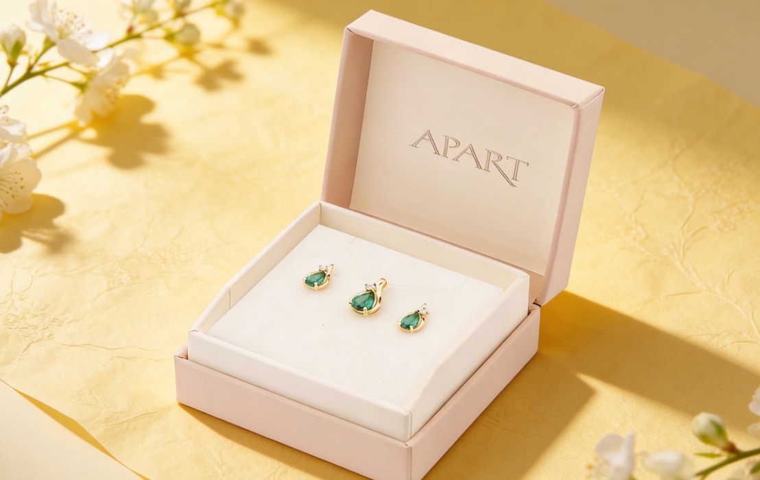 Jewellery set, earrings and pendant made of yellow gold with diamonds and emeralds in pink packaging Apart