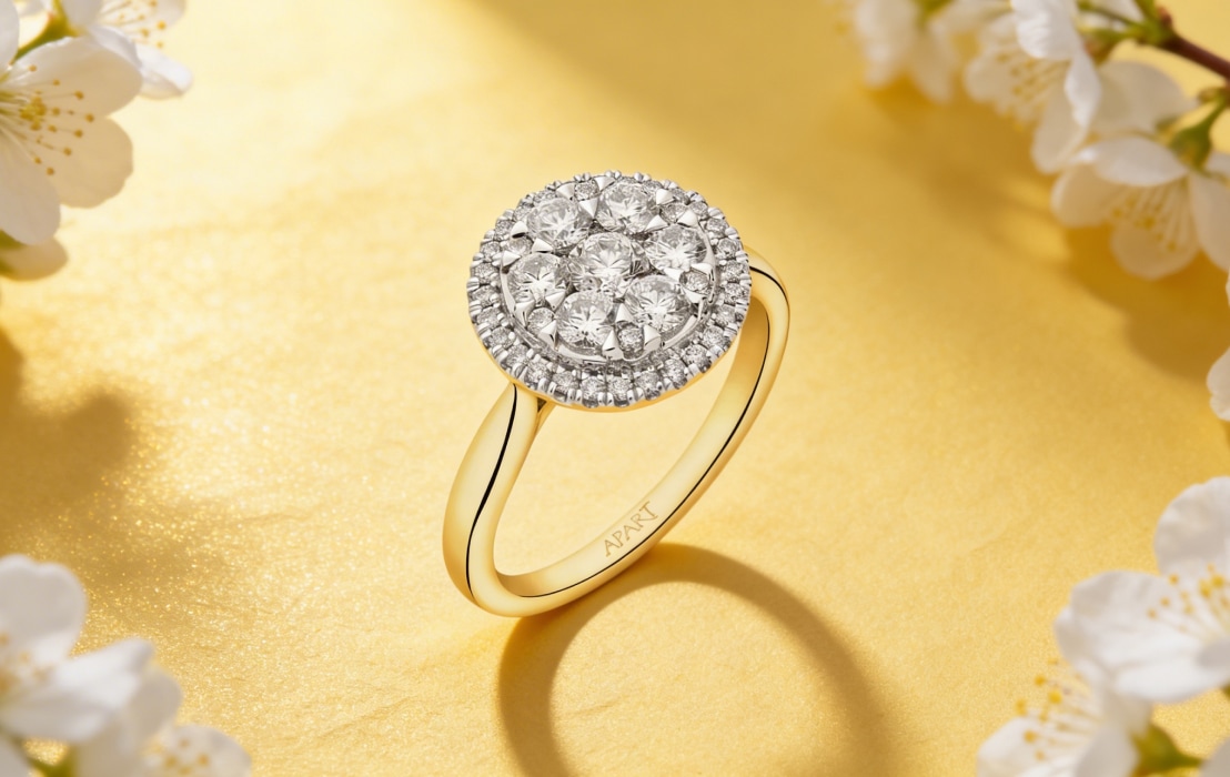 Yellow gold ring with diamonds on a yellow spring background with white flowers