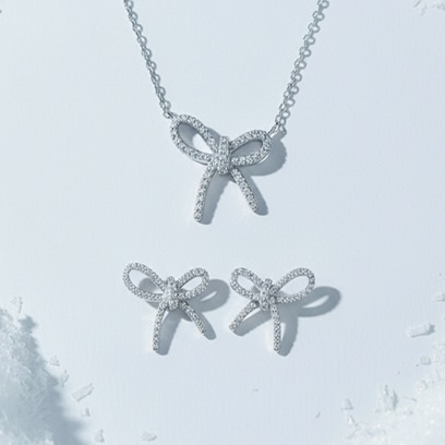a set of silver jewellery with cubic zirconias - bow motif