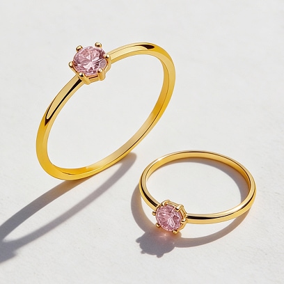 Two gold rings decorated with pink zircons