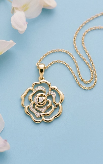 Gold necklace with a rose-shaped pendant decorated with cubic zirconias