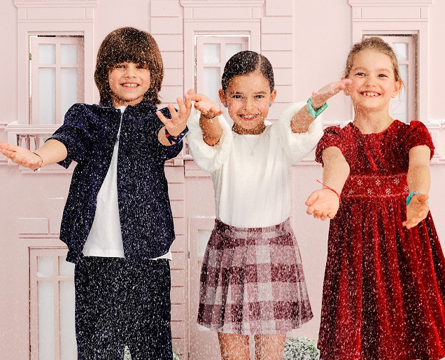 Children standing in the snow showing off jewellery from the kids collection