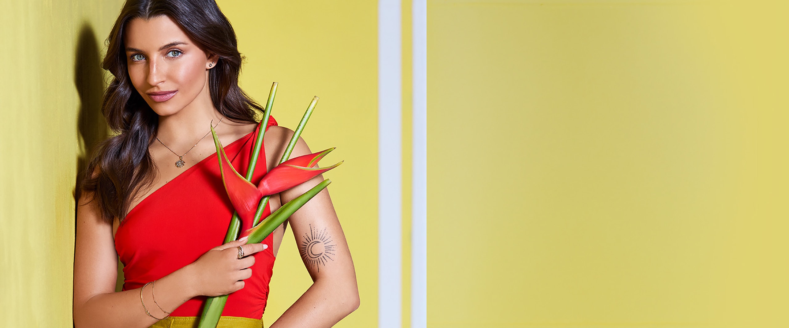 Julia Wieniawa in a red blouse with a heliconia flower and subtle gold jewellery with diamonds and diamonds