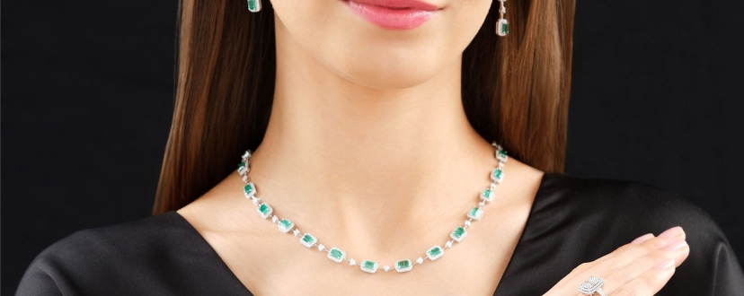 A set of white gold jewelry with diamonds and emeralds