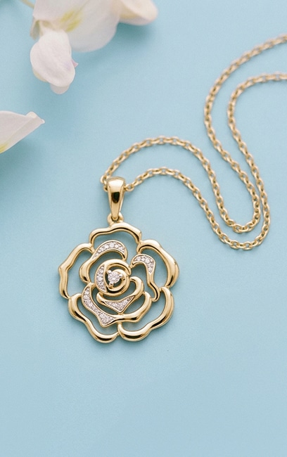 Gold necklace with a rose-shaped pendant decorated with cubic zirconias