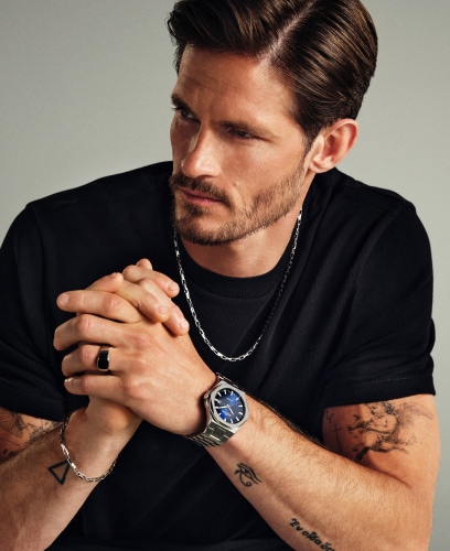 A man showing off silver jewelry and a Bergstern Active watch