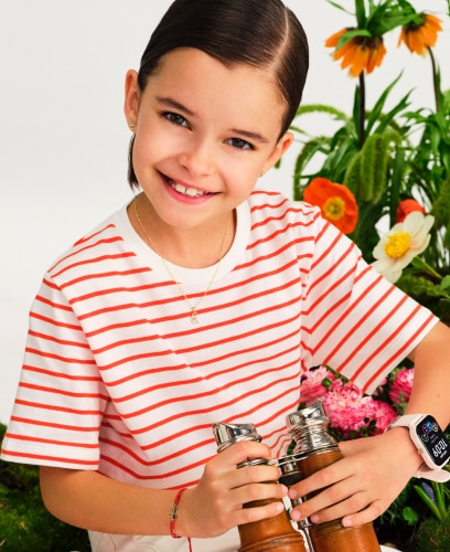 A girl in a red and white striped shirt holding binoculars. She presents jewellery and a watch for the youngest