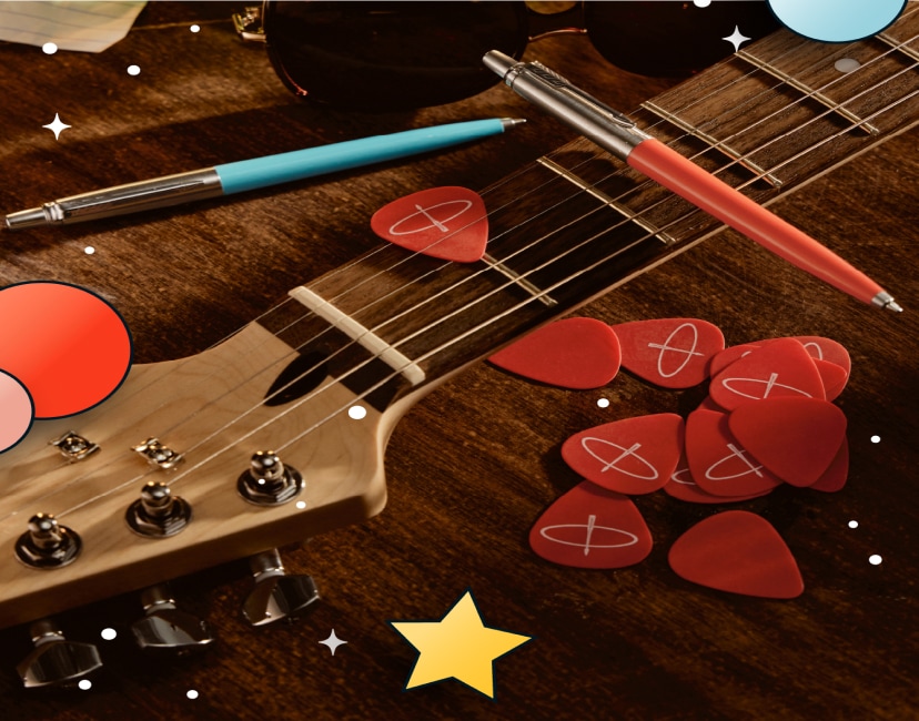 Dwa długopisy czerwony i niebieski na tle gitary
