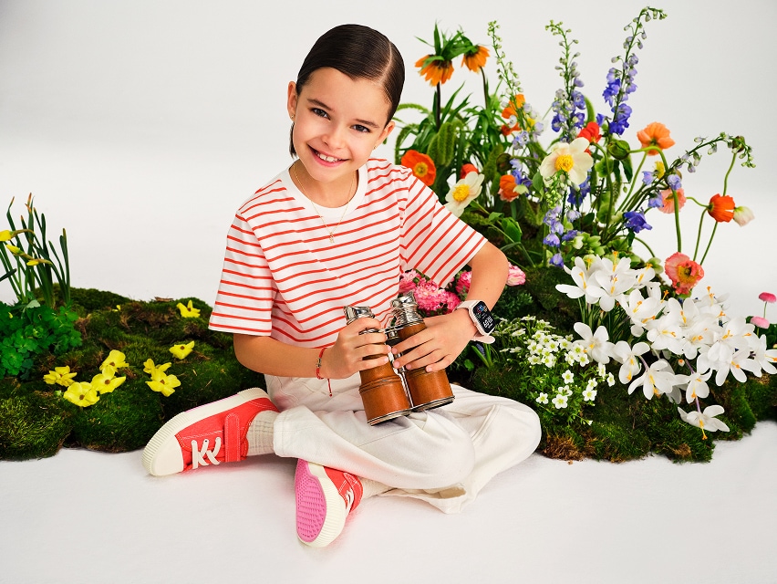 Kolekcja Kids Collection - dziewczynka na tle łąki z polnymi kwiatami prezentyjąca zegarek i bransoletkę