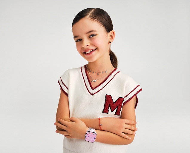 Dziewczynka prezentująca srebrną biżuterię dla dzieci oraz smartwatcha