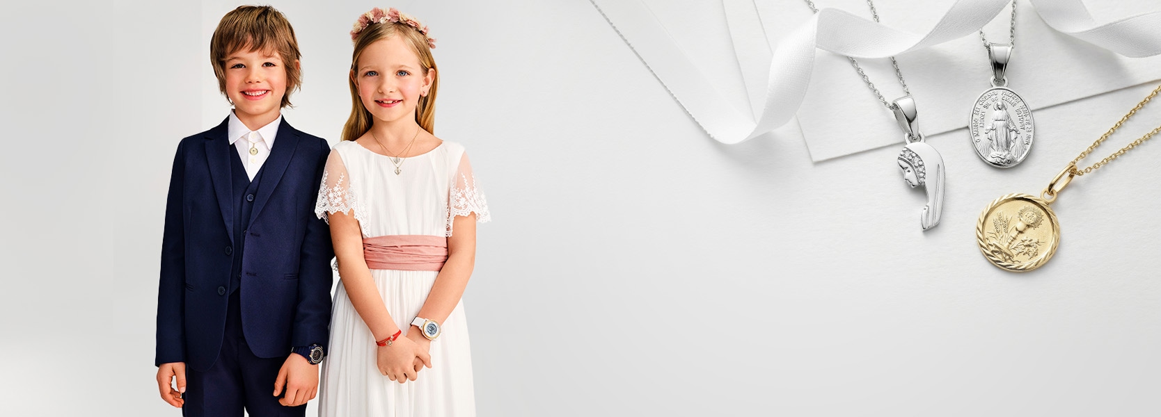 Chłopczyk i dziewczynka ubrani na elegancko prezentujący srebrne i złote medaliki