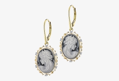 Złote kolczyki zdobione cyrkoniami, oraz namalowaną postacią kobiety na środku