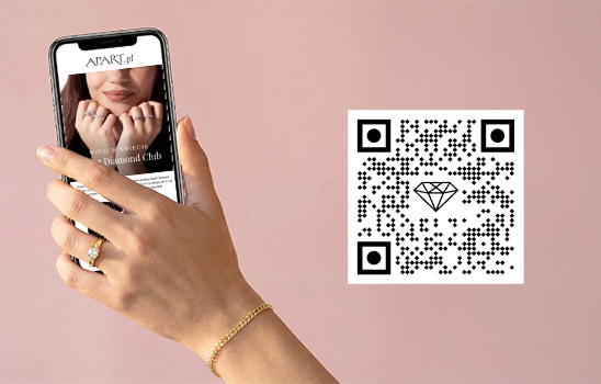 Kobieca dłoń trzymająca telefon z wyświetlonym ekranem Apart Diamond Club oraz kod QR
