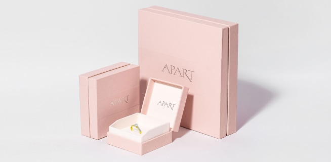 Różowe opakowania Apart, jedno otwarte z pierścionkiem w środku