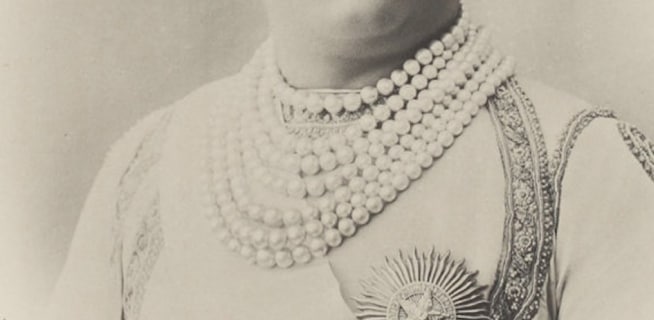 Archiwalne, czarno-białe zdjęcie maharadży noszącego luksusowy, wielorzędowy naszyjnik z dużych pereł