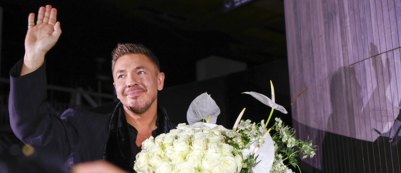 Łukasz Jemioł z bukietem białych kwiatów