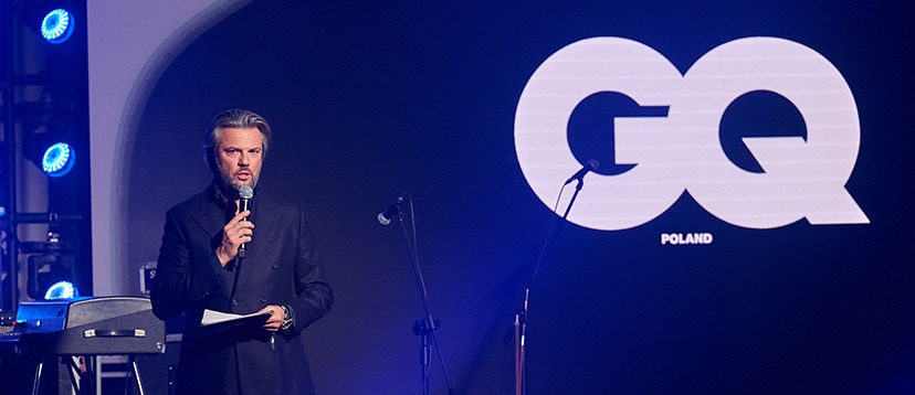 Olivier Janiak na scenie, w tle banner GQ Poland