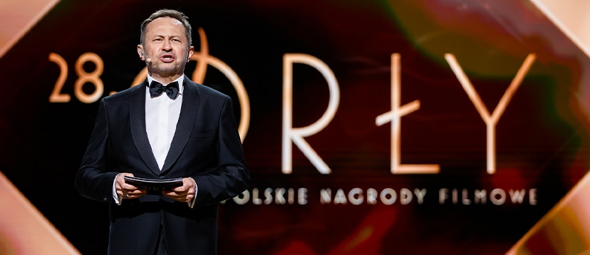 Andrzej Konopka w smokingu jako konferansjer gali Orły 2026 - Polskie nagrody filmowe, na tle logo orłów
