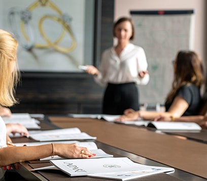 Kobieta prowadząca prezentację - w tle katalogi marki Apart