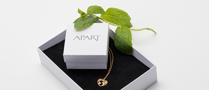 Złoty naszyjnik z zawieszką w kształcie serca w białym pudełku Apart, ozdobionym listkiem mięty