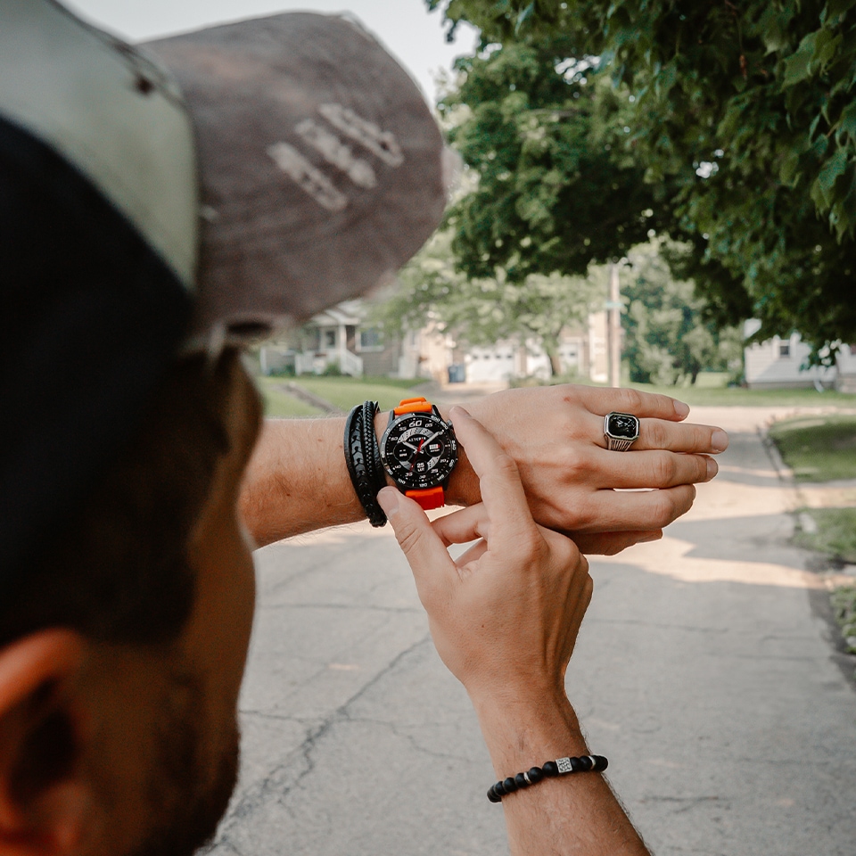 Mężczyzna monitorujący godzinę na swoim smartwatchu - w tle park