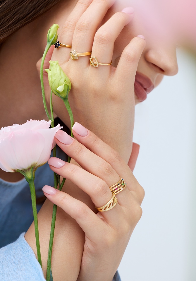 Klika złotych pierścionków z cyrkoniami założonych na dłoni