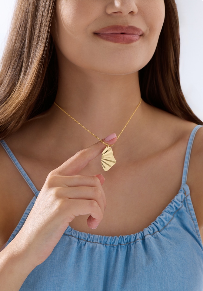 MOdelka prezentuje złoty naszyjnik