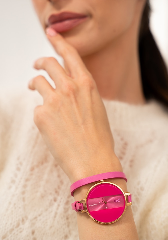 kobieta prezentująca na nadgarstku zegarek w różowej oprawie