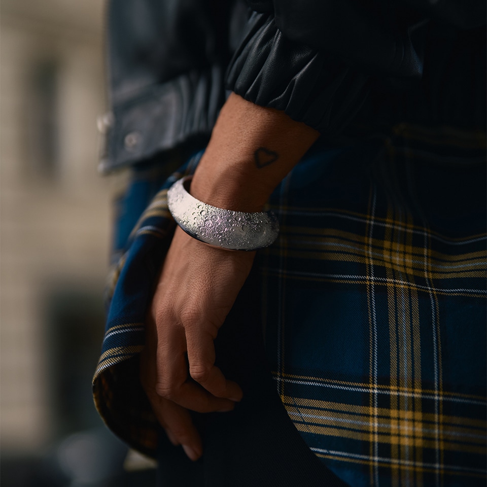 Kobieta prezentująca na nadgarstku srebrną bransoletkę z kolekcji biżuterii Julii Wieniawy