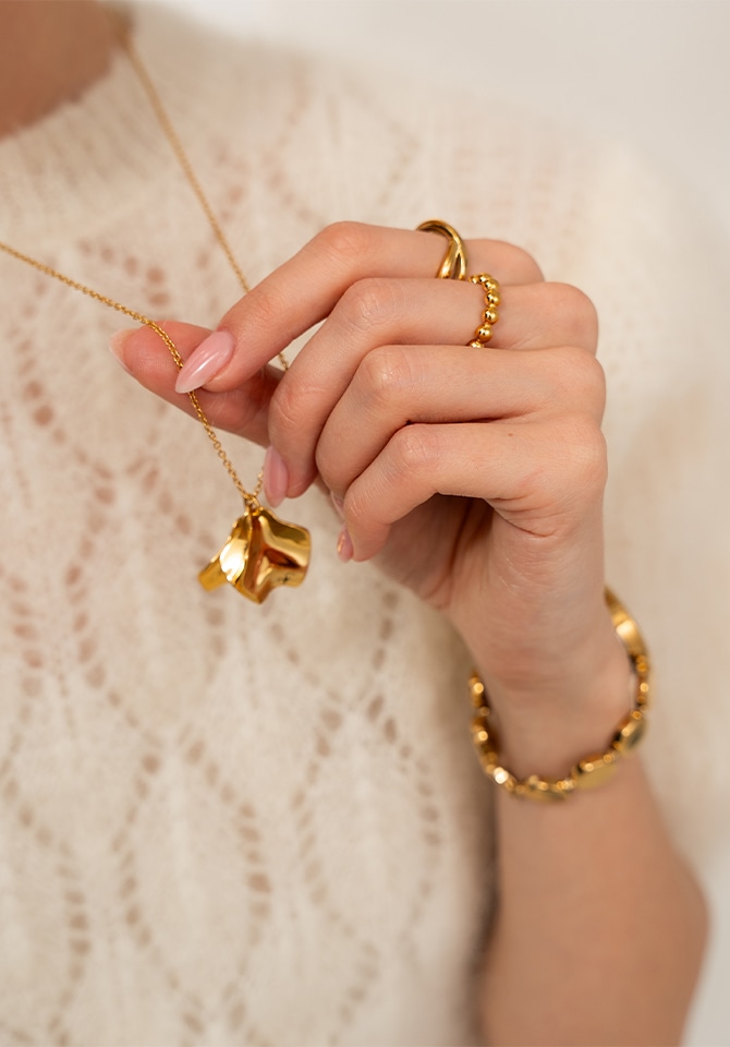 kobieta w stylizacji kompletu biżuterii pozłacanej