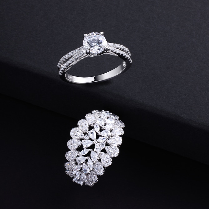 Dwa pierścionkiz diamentami na czarnym tle