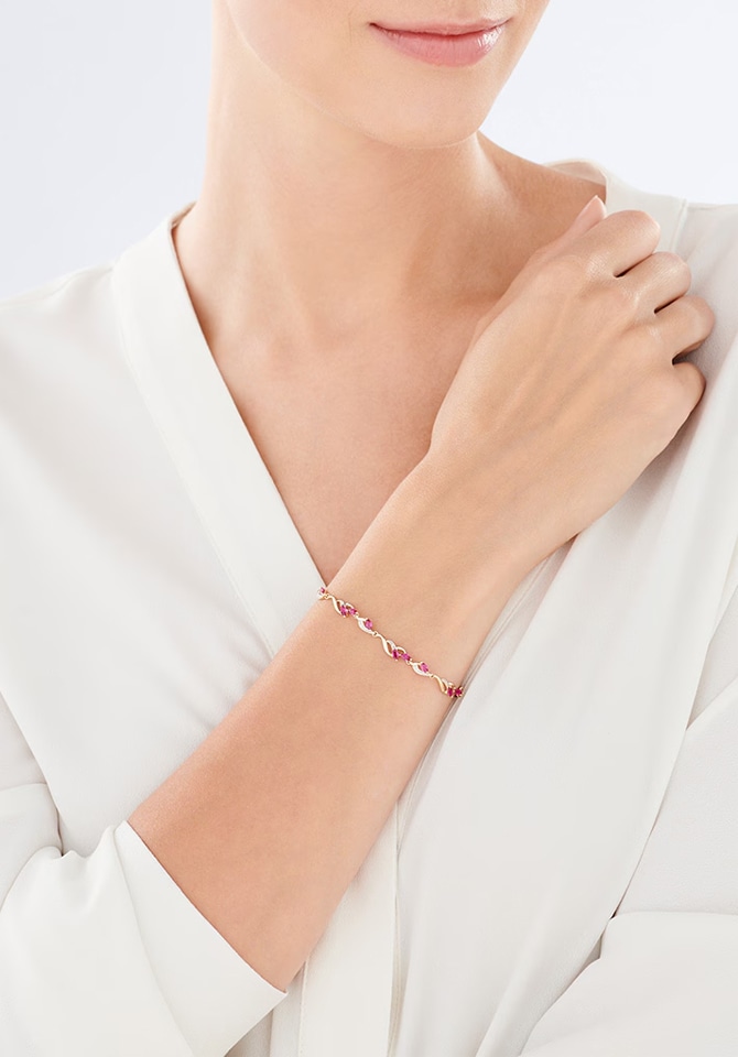 kobieta prezentująca bransoletkę srebrną z dodatkami czerwonych kamieni