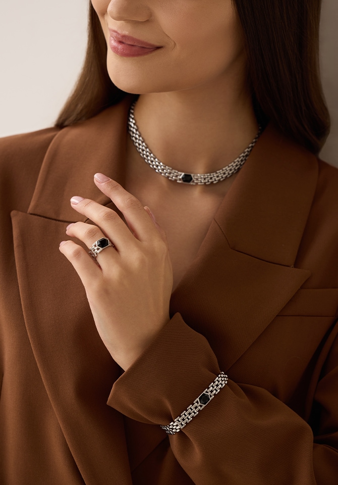 kobieta prezentująca komplet biżuteri srebrnej z czarnym kamieniem