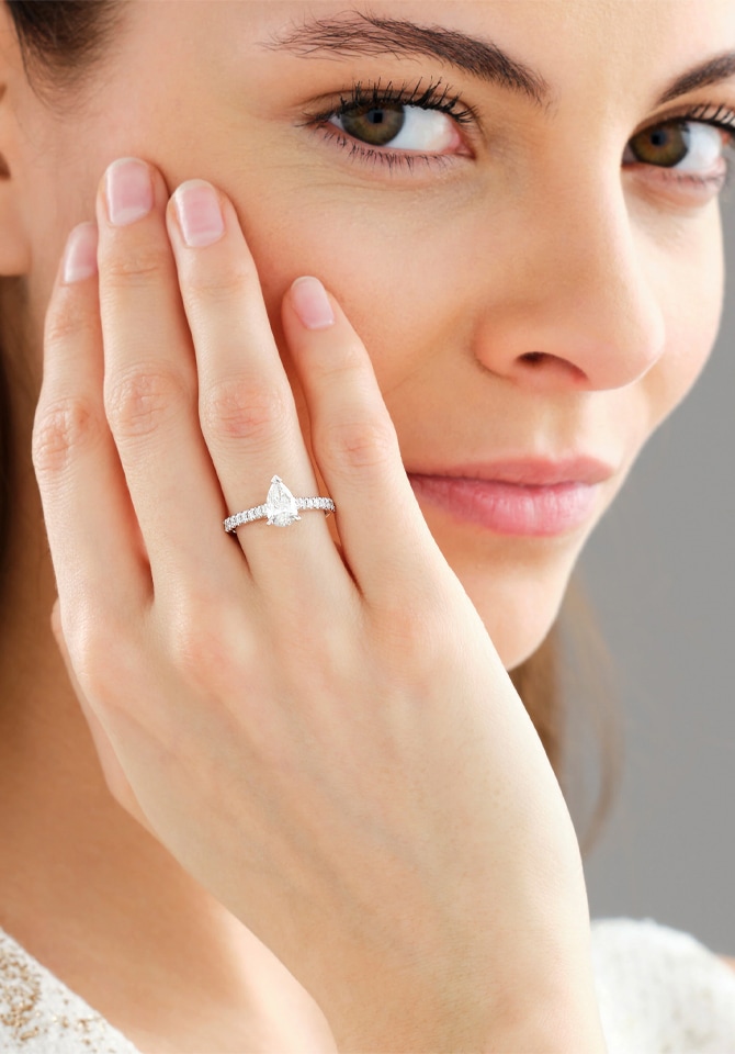 Bobieta prezentująca na palcu u dłoni pierścionek wykonany z białego złota ozdobiony diamentami