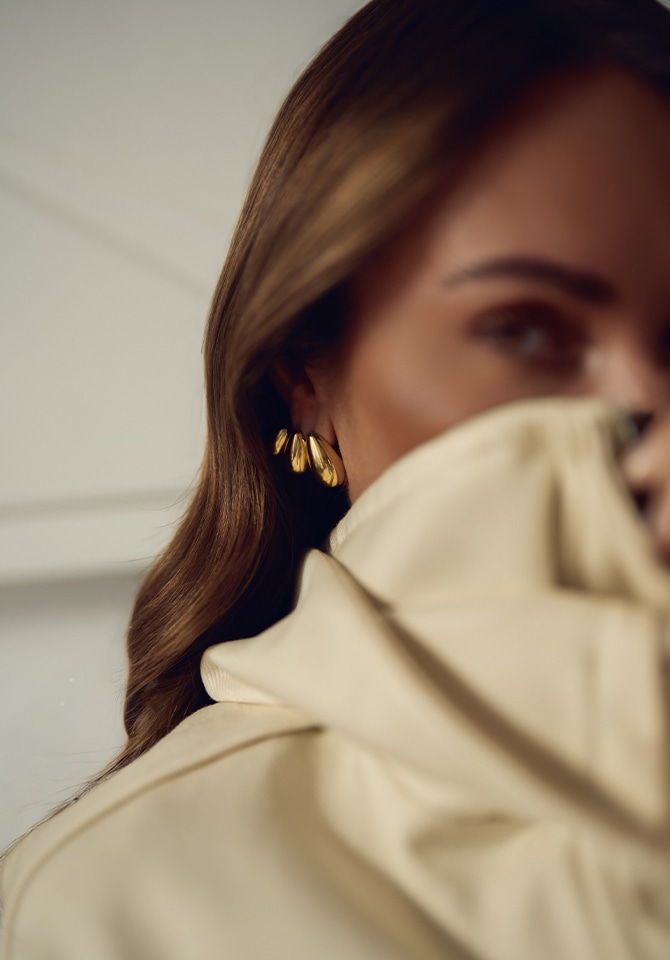 Modelka prezentująca na uszach kolczyki pozłacane w kształcie łezki