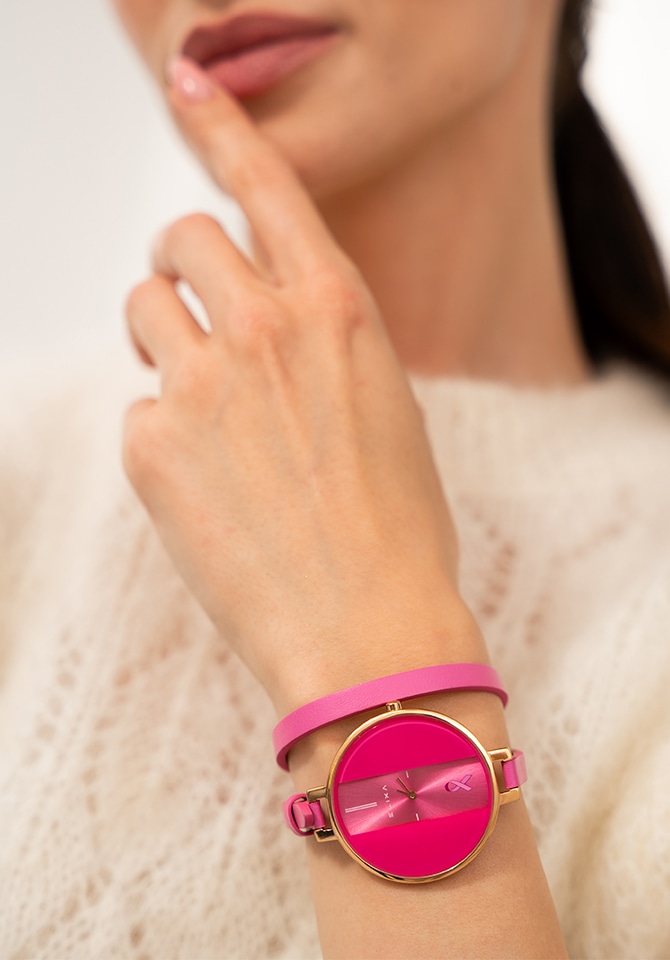 zegarek z tarczą i skórzaną opaską w kolorze różowym założony na nadgarstku kobiety