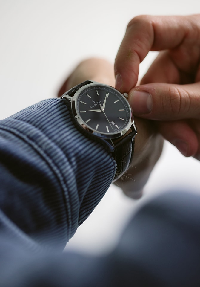 Mężczyzna prezentujący na nadgarstku zegarek z bransoletą ze skóry w kolorze granatowej czerni