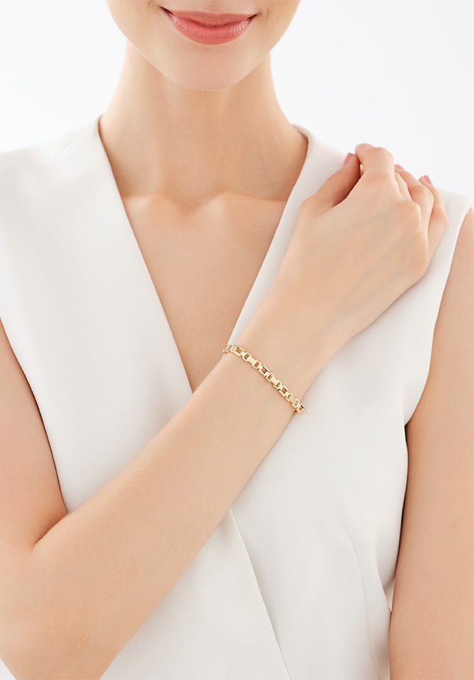 kobieta prezentująca na nadgarstku bransoletkę złotą