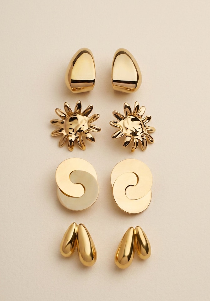 Złote kolczyki o różnych kształtach jak - koła ósemki, łezki i słońce