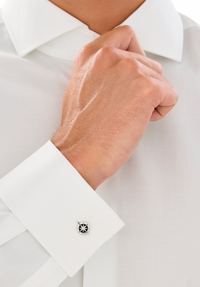 Zbliżenie na biały mankiet koszuli z elegancką srebrną spinką z okrągłym zdobieniem